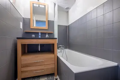 a bathroom with a tub and a sink and a mirror at Superbe appartement avec parking gratuit en centre ville et aux pieds des pistes in Chamonix-Mont-Blanc