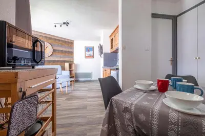 a kitchen and a dining room with a table at Superbe appartement avec parking gratuit en centre ville et aux pieds des pistes in Chamonix-Mont-Blanc