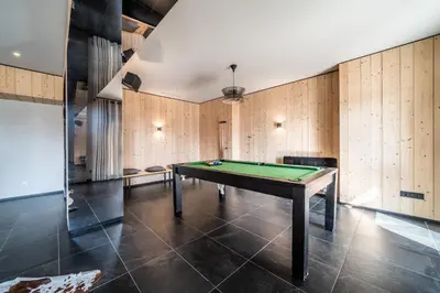 a pool table in a room with wooden walls at Apartment Le Gui Chamonix - BY EMERALD STAY in Chamonix-Mont-Blanc