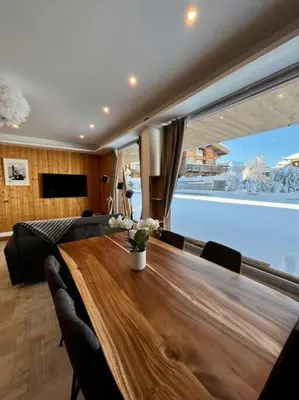 a dining room with a long wooden table and chairs at Megeve centre in Megève