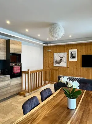 a living room with a wooden table and a kitchen at Megeve centre in Megève