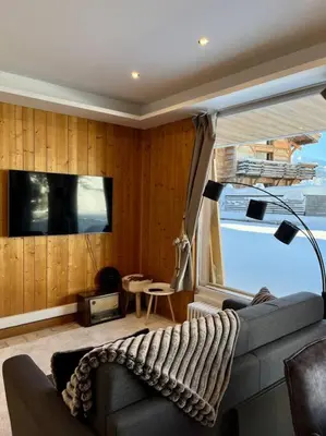 a living room with a couch and a television at Megeve centre in Megève