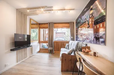 a living room with a couch and a tv at Studio l'Orée - City centre - Megève in Megève