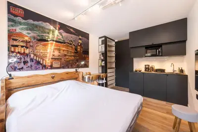 a bedroom with a large white bed and a kitchen at Studio l'Orée - City centre - Megève in Megève