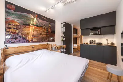 a bedroom with a large white bed and a kitchen at Studio l'Orée - City centre - Megève in Megève