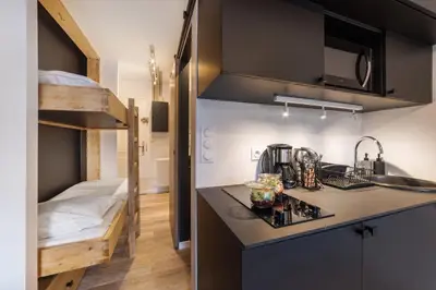 a small kitchen with a sink and a bunk bed at Studio l'Orée - City centre - Megève in Megève