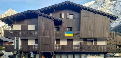 a building with a balcony with mountains in the background at Lilas - Awesome view of the Mont-Blanc Range in Les Houches