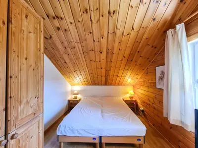 a bed in a room with a wooden ceiling at Chalet confortable à Flaine avec poêle et WIFI - FR-1-425-198 in Arâches-la-Frasse