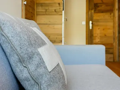a gray couch with a logo on it in a room at Pti bout villlage Megeve in Megève