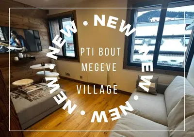 a living room with a couch and a window at Pti bout villlage Megeve in Megève