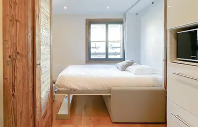 a small bedroom with a bed and a window at Pti bout villlage Megeve in Megève