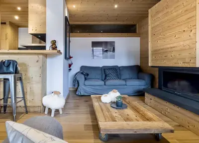 a living room with a blue couch and a fireplace at Luxury Wood Megeve village in Megève