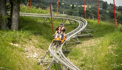 a group of people riding on a roller coaster at Luxury Wood Megeve village in Megève
