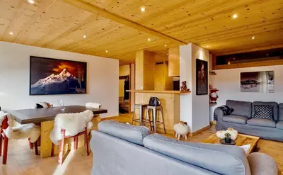 a living room with a blue couch and a table at Luxury Wood Megeve village in Megève