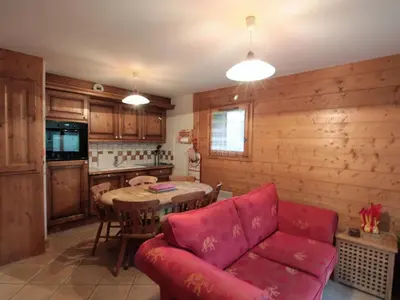 a living room with a red couch and a table at Appartement 3 pièces cabine, 6 pers, face au spa et au ski bus, proche pistes et commodités - FR-1-572-45 in Arâches-la-Frasse