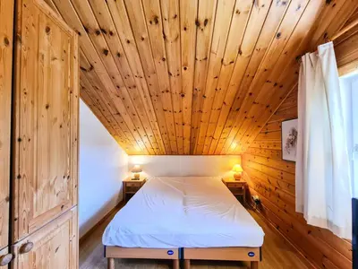 a bedroom with a bed in a wooden ceiling at Résidence Hameau - Chalet confortable · Poêle à bois · Terrasse · Garage · WIFI gratuit MAE-8714 in Magland