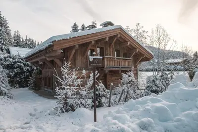 a log cabin in the snow with a sign in front at Pas de l’Ourson - Megève - Chalet with Sauna in Megève
