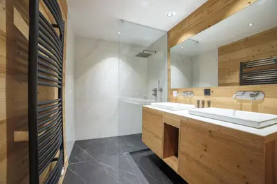 a bathroom with two sinks and a shower at Pas de l’Ourson - Megève - Chalet with Sauna in Megève
