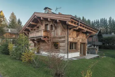 a large wooden house with a balcony on a yard at Pas de l’Ourson - Megève - Chalet with Sauna in Megève