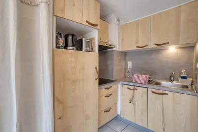 a kitchen with wooden cabinets and a sink at Duplex familial - Piscine intérieure in Saint-Gervais-les-Bains