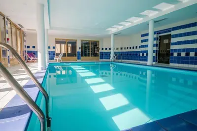 a large swimming pool with blue and white tiles at Duplex familial - Piscine intérieure in Saint-Gervais-les-Bains