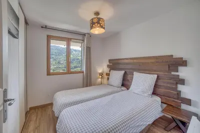a bedroom with two beds and a window at Duplex familial - Piscine intérieure in Saint-Gervais-les-Bains