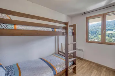 a bedroom with two bunk beds and a window at Duplex familial - Piscine intérieure in Saint-Gervais-les-Bains