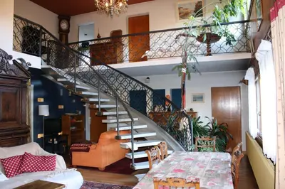 a spiral staircase in a living room with a table at La Maison des Praz in Saint-Gervais-les-Bains