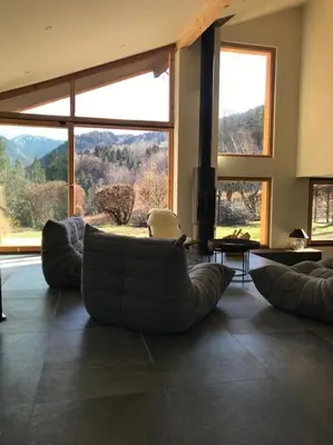 a living room with a couch and a large window at LE REFUGE DE LUCE in Saint-Gervais-les-Bains