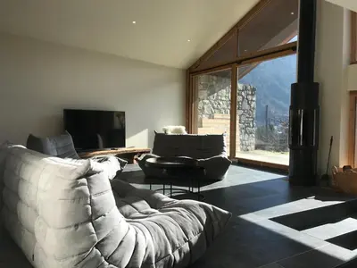 a living room with a couch and a tv at LE REFUGE DE LUCE in Saint-Gervais-les-Bains