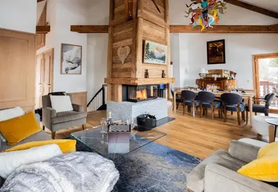 a living room with a fireplace and a table at Chalet Albert 1 er Megeve village in Megève