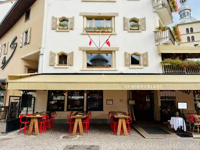 a restaurant with tables and chairs in front of a building at Chalet Albert 1 er Megeve village in Megève