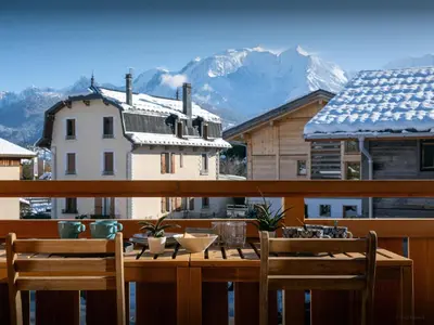 a table and chairs on a balcony with a mountain at Chalet Alpayak - OVO Network in Combloux
