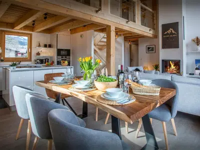 a dining room with a wooden table and chairs at Chalet Alpayak - OVO Network in Combloux
