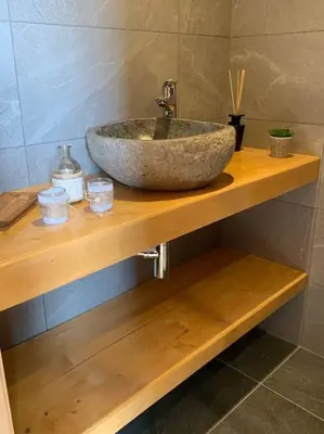 a stone sink on a wooden shelf in a bathroom at Chalet****Luxe Sauna & SPA Le Champenois in Samoëns