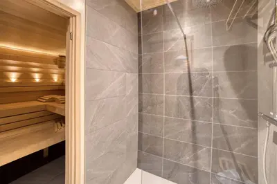a shower with a glass door in a sauna at Chalet****Luxe Sauna & SPA Le Champenois in Samoëns