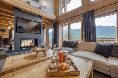 a living room with a couch and a fireplace at Chalet****Luxe Sauna & SPA Le Champenois in Samoëns
