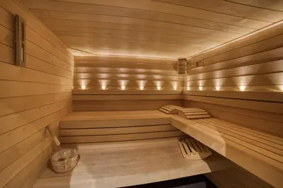 a sauna with wooden floors and benches in it at Chalet****Luxe Sauna & SPA Le Champenois in Samoëns
