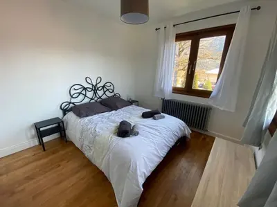 a bedroom with a bed with white sheets and a window at Logement entier dans maison - Passy - 6 personnes in Passy