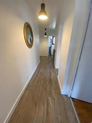 a hallway with white walls and wooden floors and a mirror at Logement entier dans maison - Passy - 6 personnes in Passy