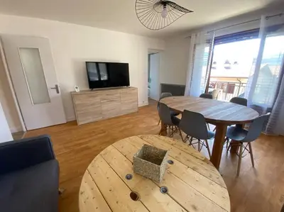 a living room with a wooden table and a television at Logement entier dans maison - Passy - 6 personnes in Passy