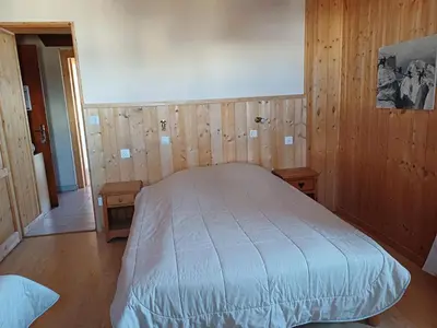 a bedroom with a bed with wooden walls and wooden floors at chalet Mont-Blanc in Combloux