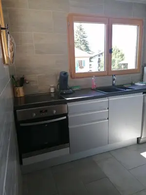a kitchen with a stove and a sink and a window at chalet Mont-Blanc in Combloux