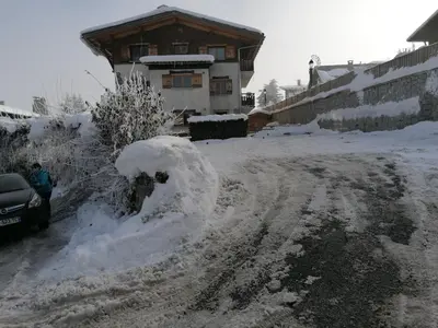 a snow covered road in front of a house at chalet Mont-Blanc in Combloux