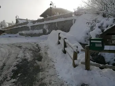 a fence covered in snow next to a house at chalet Mont-Blanc in Combloux