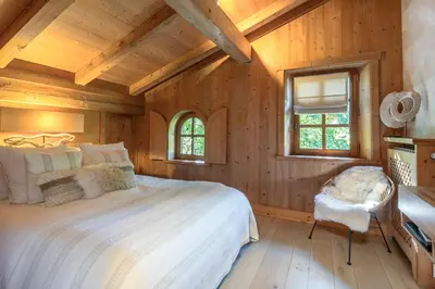 a bedroom with wooden walls and a bed and a window at Chalet White Moon in Demi-Quartier