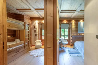 a bedroom with wooden walls and wooden flooring at Chalet White Moon in Demi-Quartier