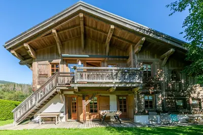 an exterior view of a log home with a large deck at Chalet White Moon in Demi-Quartier