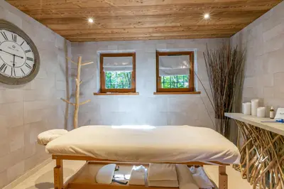 a room with a bed and a clock on the wall at Chalet White Moon in Demi-Quartier