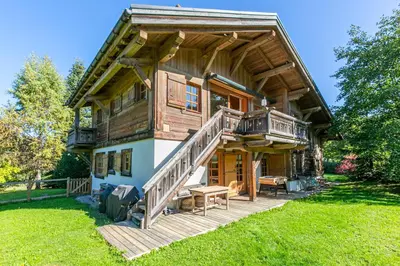 a large log cabin with a deck and stairs to the porch at Chalet White Moon in Demi-Quartier